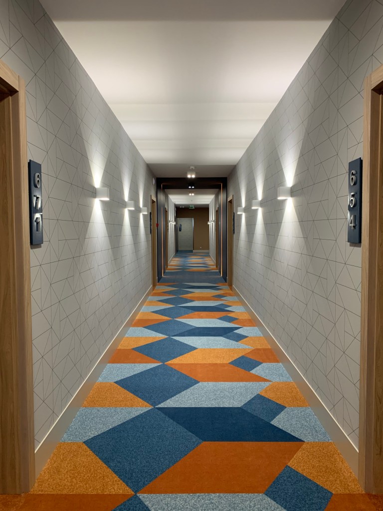 Hotel Európa fit apartman közlekedő részlet, szintenként változó színű szobaszámokkal